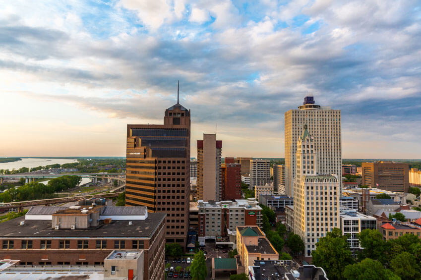 Aerial view of a cityscape featuring several tall buildings with a river and bridges visible in the background under a partly cloudy sky. Aerial view of a cityscape featuring several tall buildings with a river and bridges visible in the background under a partly cloudy sky.