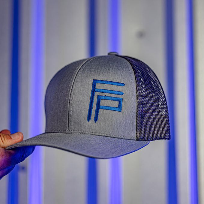 Gray baseball cap with a mesh back, featuring blue stylized letters "FP" on the front, held up against a vertically striped background with blue lighting.